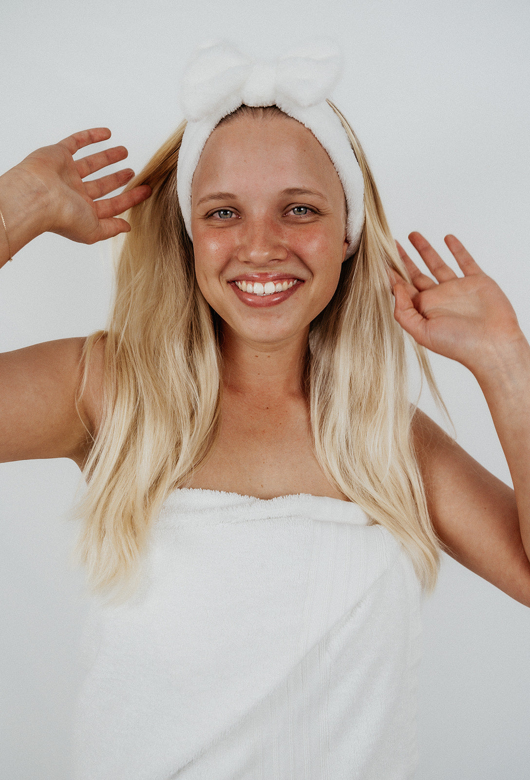fluffy white ks kindred skincare headband to use for skincare routine to wash face with and keep hair back blonde girl wearing it whilst washing her face with all skin types deep sea gel cleanser
