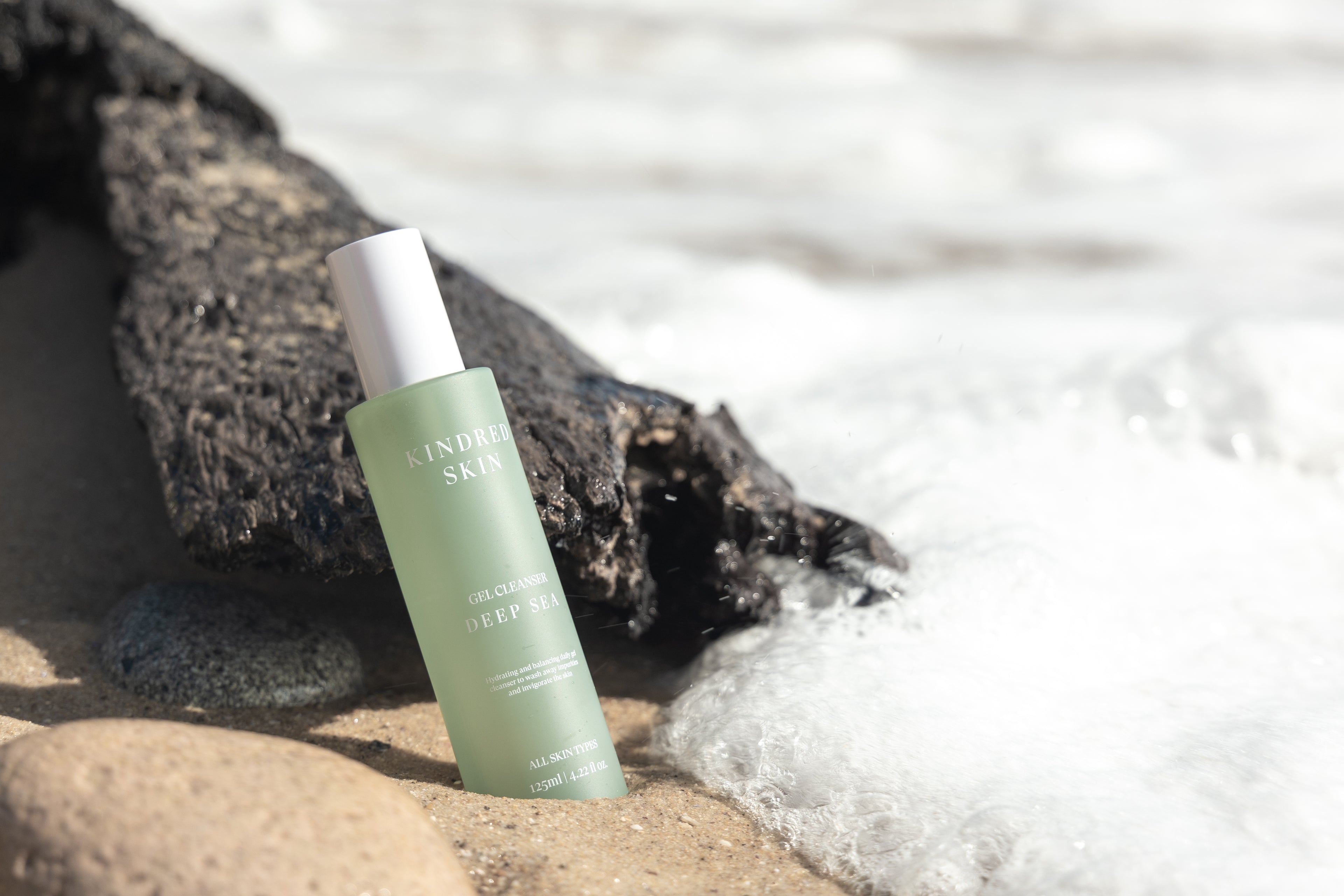 gel cleanser at the ocean in the water at the beach in the sand with a wave coming up to it become a stockist for an australian skincare brand Kindred Skin to ease confusion around skin-care, by getting the basics right through skin hygiene innovations. So that women of any skin type, can feel fresh and motivated to reach their full potential - every single day. with gel cleanser, face towels and headband products